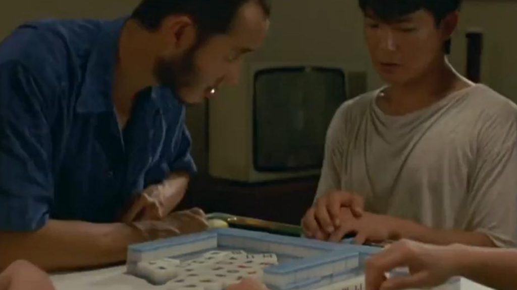 Two guys and two beautiful women playing mahjong, one has been pointing guns, pointing to hand shaking